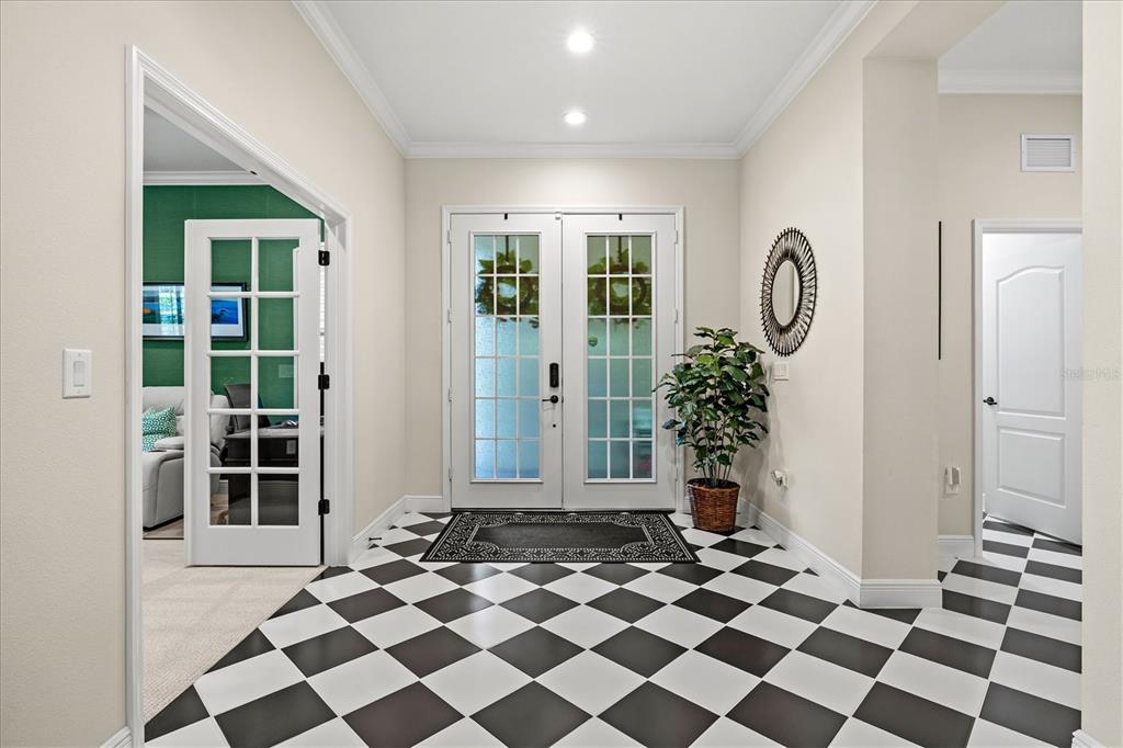 An entryway features a black and white checkered floor, double glass doors, and a potted plant — 21221 WACISSA DRIVE, VENICE, FL