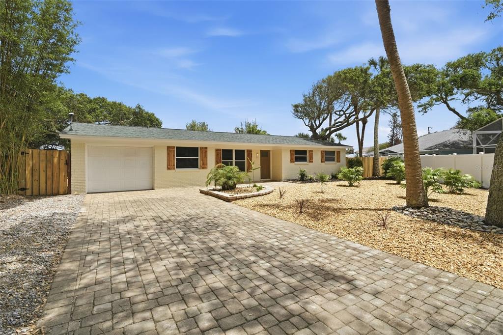 A single-story house with a brick exterior, a paver driveway, and a gravel front yard — 1 CARLEY CIRCLE, NEW SMYRNA BEACH, FL