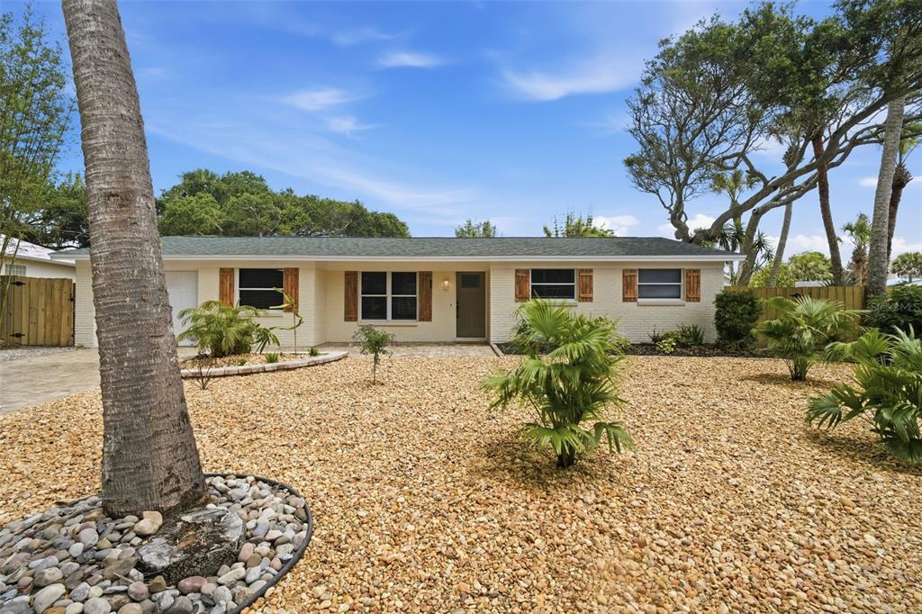 A single-story house with a brick exterior, shutters, and a gravel front yard — 1 CARLEY CIRCLE, NEW SMYRNA BEACH, FL