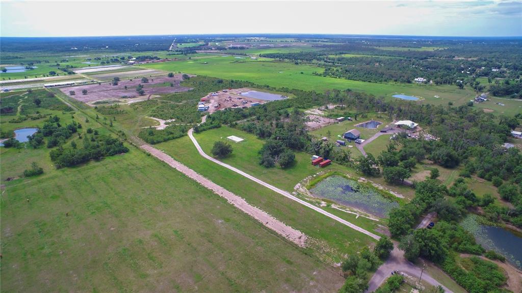 An aerial view shows a rural property with multiple ponds, scattered trees, and gravel roads — 7977 BARR ROAD, MYAKKA CITY, FL