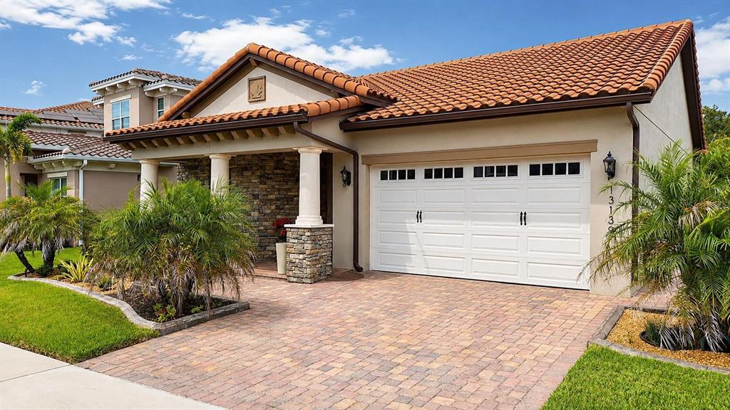 A single-story house with a tiled roof, stone accents, and a paved driveway — 13139 BROMBOROUGH DRIVE, ORLANDO, FL