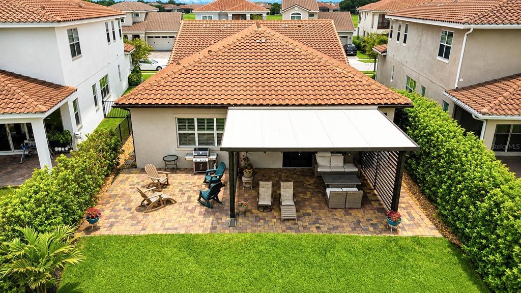 An aerial view of a backyard patio with a covered pergola and paver flooring — 13139 BROMBOROUGH DRIVE, ORLANDO, FL