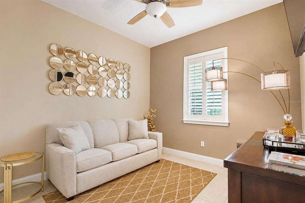 A living room features a beige sofa, a circular mirror wall art, and a floor lamp — 13139 BROMBOROUGH DRIVE, ORLANDO, FL