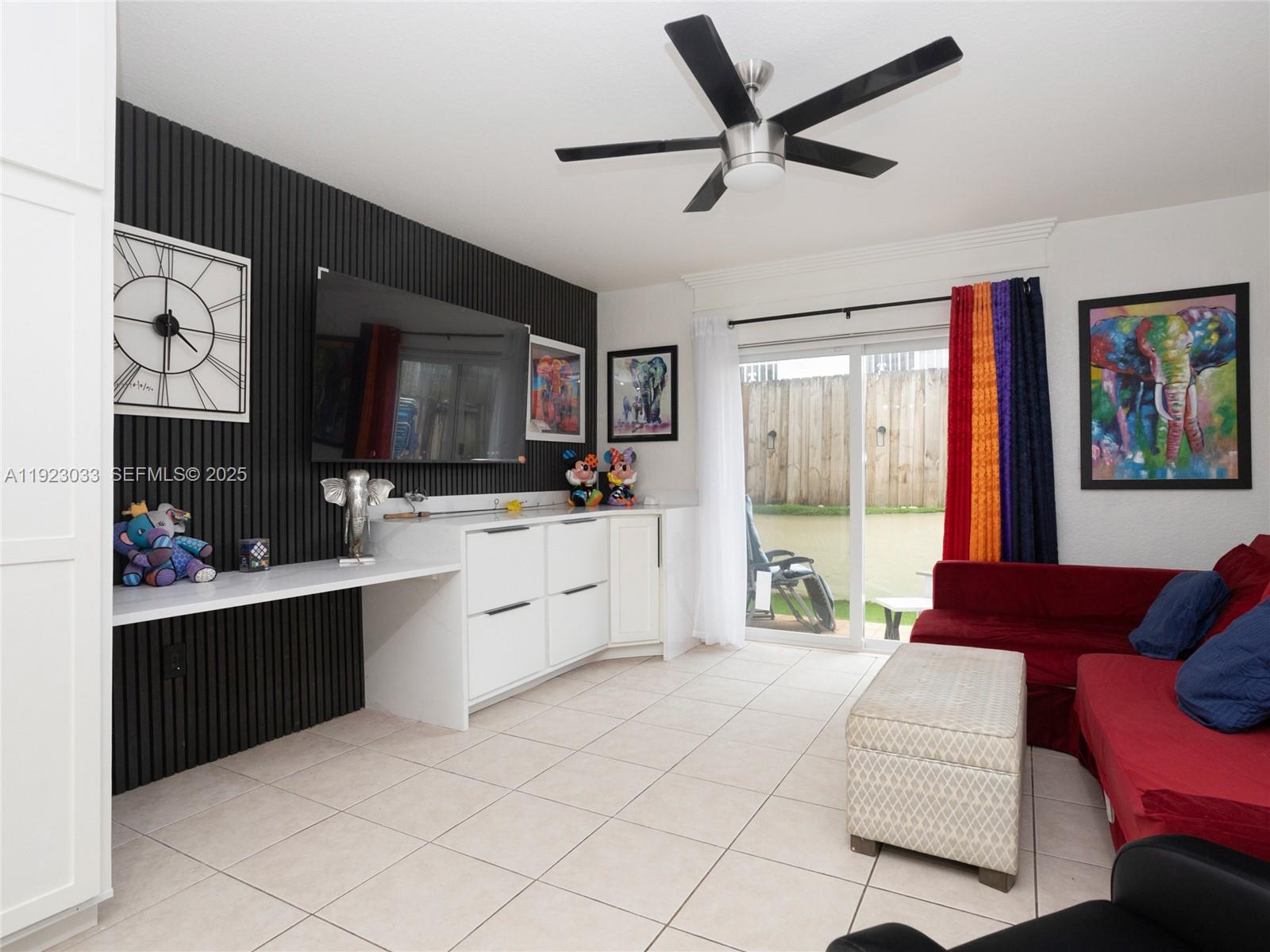 A living room features a black slatted accent wall, white cabinetry, and a red sofa — 437 SW 3rd St # 2, Miami FL 33130, MIAMI, FL