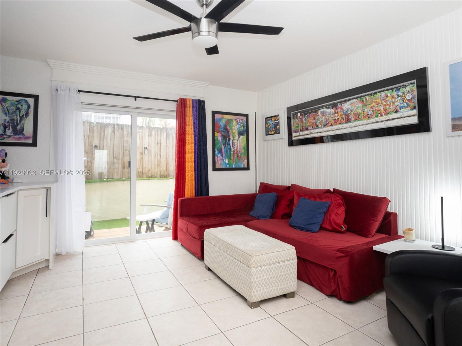 A living room features a red sectional sofa, a patterned ottoman, and a sliding glass door — 437 SW 3rd St # 2, Miami FL 33130, MIAMI, FL