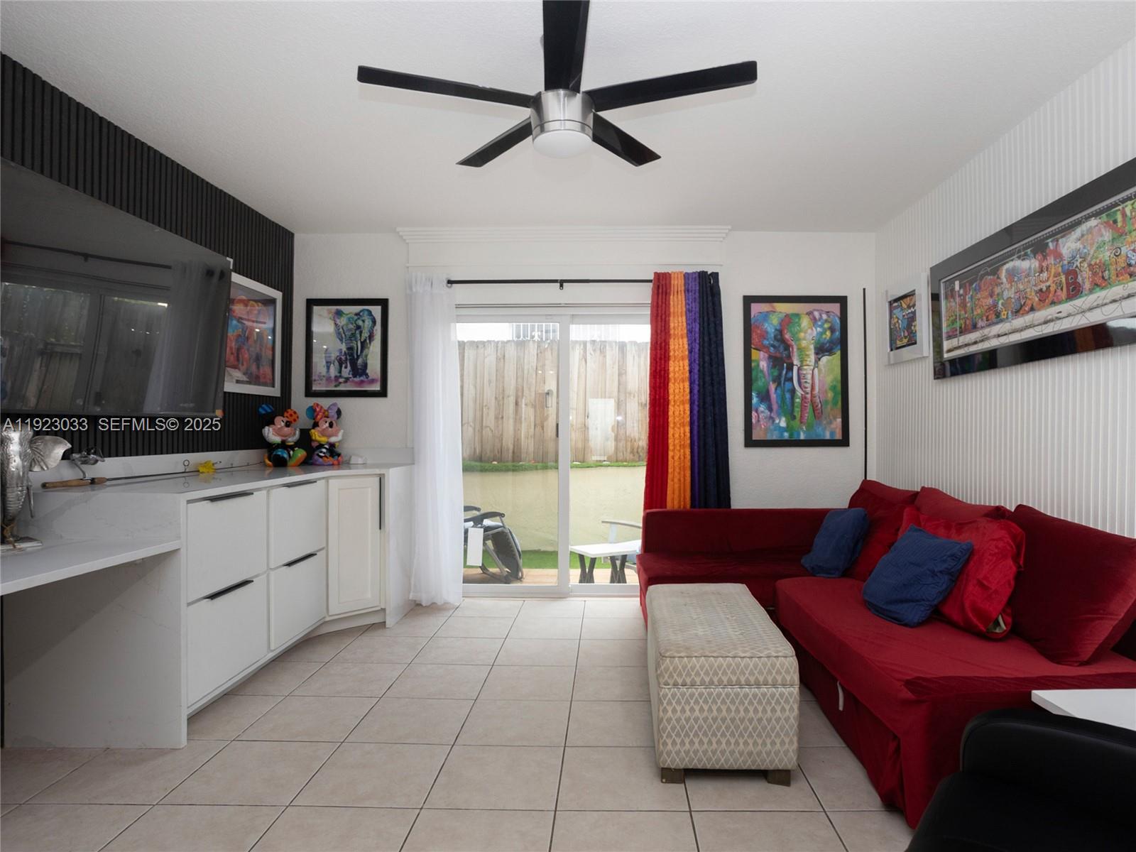 A living room features a red sectional sofa, white cabinetry, and a sliding glass door — 437 SW 3rd St # 2, Miami FL 33130, MIAMI, FL