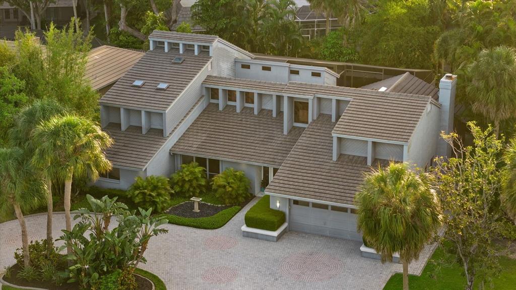 An aerial view of a multi-level house with a tiled roof and a paved driveway — 4891 PEREGRINE POINT E, SARASOTA, FL