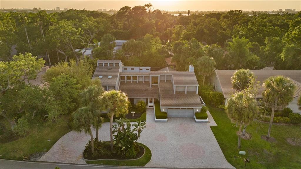 An aerial view of a multi-level house with a tiled roof and a paved driveway — 4891 PEREGRINE POINT E, SARASOTA, FL