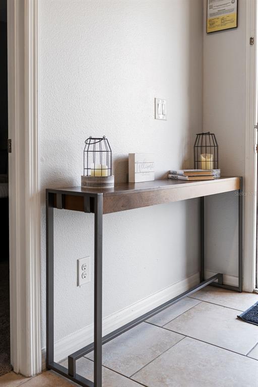 A narrow wooden console table with a metal frame sits against a white wall — 4671 TERRASONESTA DRIVE, DAVENPORT, FL