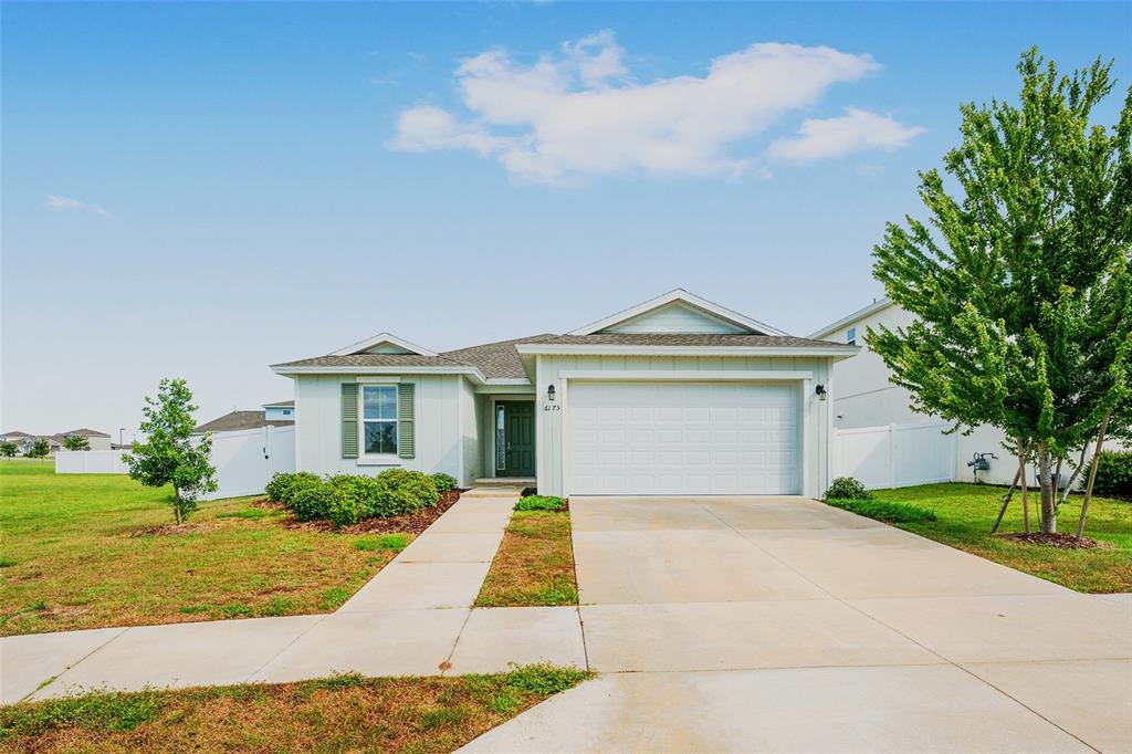 A single-story house with a white garage, green shutters, and a concrete driveway — 6175 SW 74TH COURT, OCALA, FL