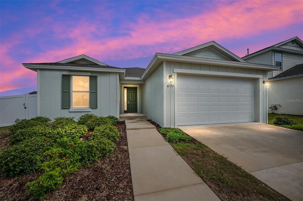 A single-story house with a white exterior, a two-car garage, and a front walkway — 6175 SW 74TH COURT, OCALA, FL
