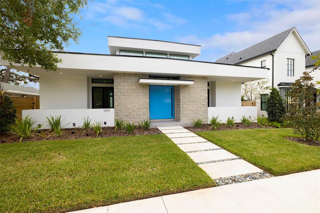 A modern single-story house with a bright blue front door and a stone facade — 1304 W FRIBLEY STREET, TAMPA, FL