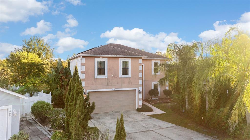 A two-story stucco house with a two-car garage and a concrete driveway — 1009 RONLIN STREET, HAINES CITY, FL