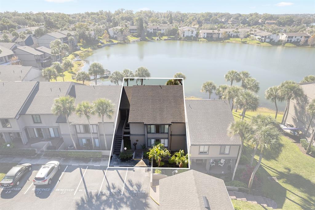 An aerial view shows a multi-story townhouse unit with a lakefront backyard and parking — 670 LAKE VILLAS DRIVE UNIT C, ALTAMONTE SPRINGS, FL