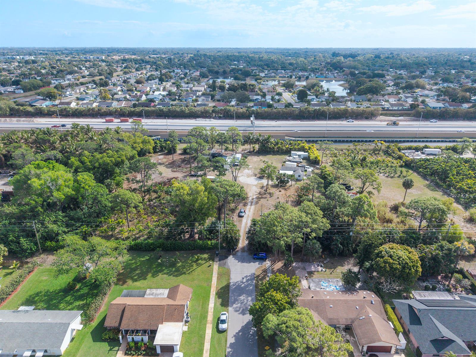 An aerial view shows a residential property with a long driveway leading to wooded land — 5387 80th Trail S, Lake Worth FL 33467, LAKE WORTH, FL