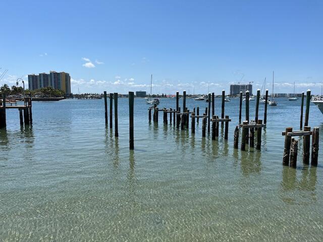 A view of wooden pilings in clear water with boats and buildings in the distance — 2715 Lake Drive, Riviera Beach FL 33404, RIVIERA BEACH, FL