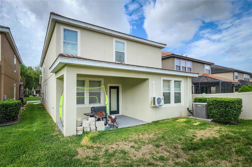 The exterior of a two-story house features a covered patio, a grill, and a yard — 949 TERRA VISTA STREET, BRANDON, FL