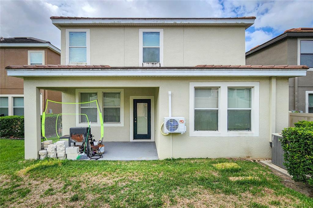 The exterior view shows a covered patio with a grill and a wall-mounted air conditioner — 949 TERRA VISTA STREET, BRANDON, FL