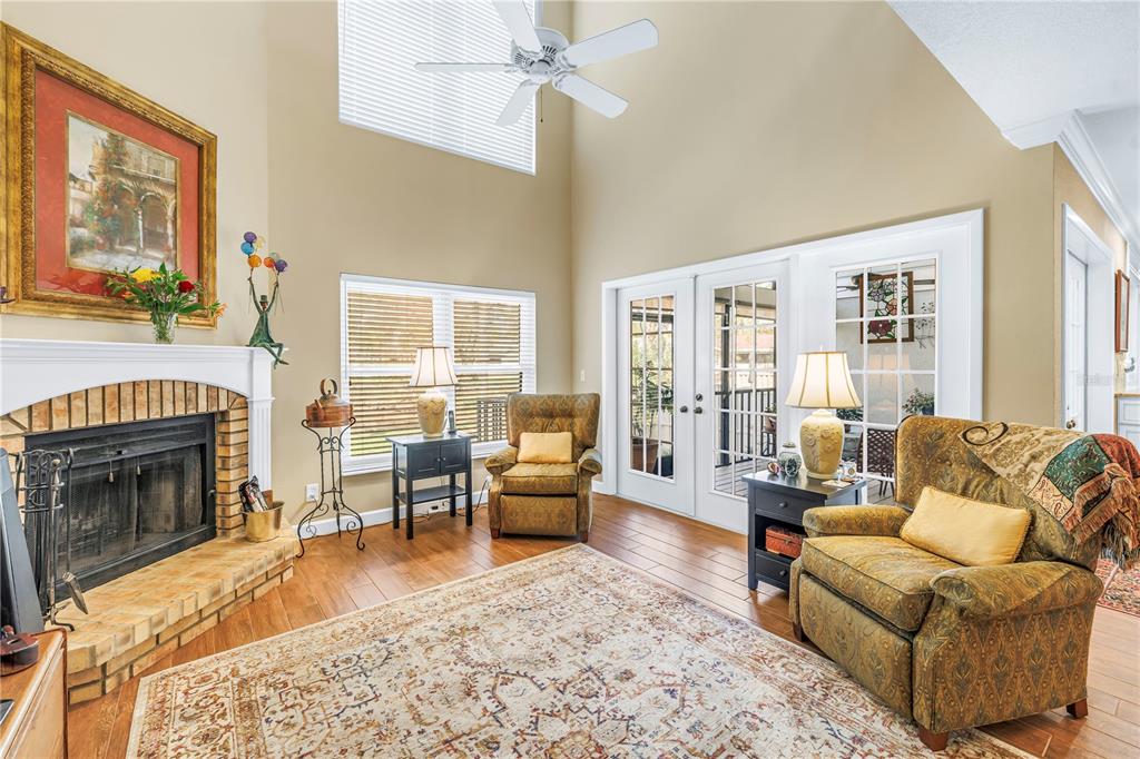 A paved patio leads to a grassy backyard with palm trees and a pond view — 812 AMELIA COURT NE, ST PETERSBURG, FL