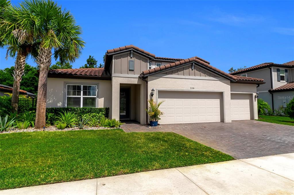 An aerial view shows three suburban houses with tiled roofs, swimming pools, and screened lanais — 7336 GREAT EGRET BOULEVARD, SARASOTA, FL