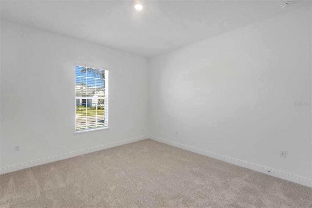 An empty bedroom features white walls, beige carpeting, and a single window — 14371 CREST PALM AVENUE, WINDERMERE, FL