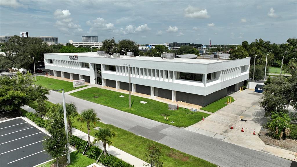 An aerial view shows a two-story white commercial building with a flat roof and parking — 3707 W CHERRY STREET, TAMPA, FL