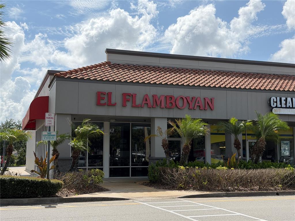 The exterior of a commercial building features a red sign reading El Flamboyan — 12141 S ORANGE BLOSSOM TRAIL, ORLANDO, FL