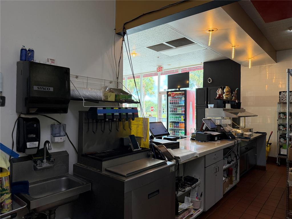 A commercial kitchen service counter features a stainless steel sink, soda fountain, and POS system — 12141 S ORANGE BLOSSOM TRAIL, ORLANDO, FL