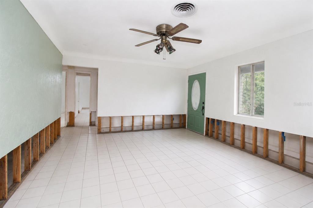 An unfinished living room with tile flooring, exposed wall studs, and a ceiling fan — 525 HAMPTON AVENUE NE, ST PETERSBURG, FL