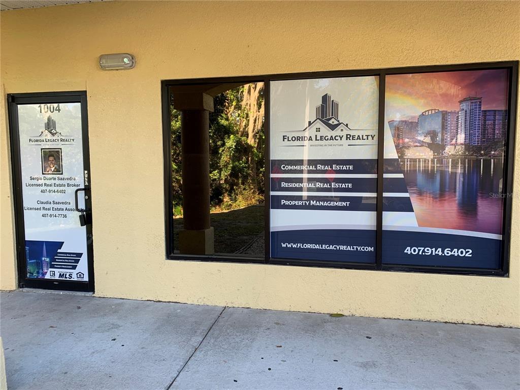 The exterior of a commercial office space features glass windows and a door with signage — 1004 PLAZA DRIVE UNIT 105, KISSIMMEE, FL