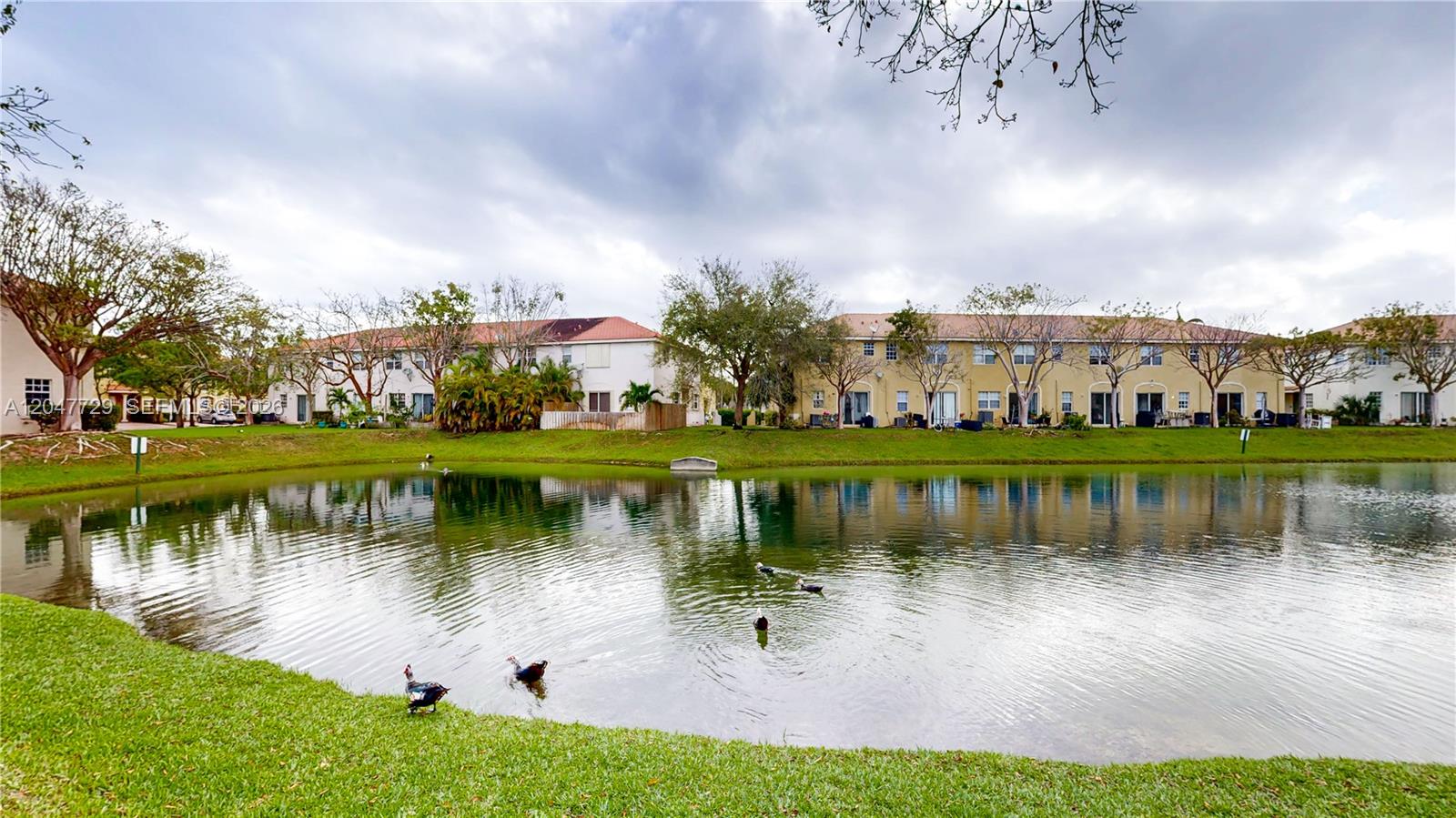 A pond sits in front of multi-story residential buildings with ducks on the grassy bank — 531 NE 21st Ave, Homestead FL 33033, HOMESTEAD, FL