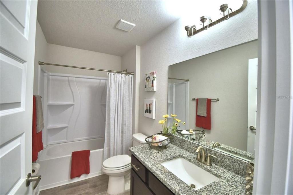 A bathroom features a glass-enclosed walk-in shower and a soaking tub with black fixtures — 2388 NW 23RD AVENUE, OCALA, FL