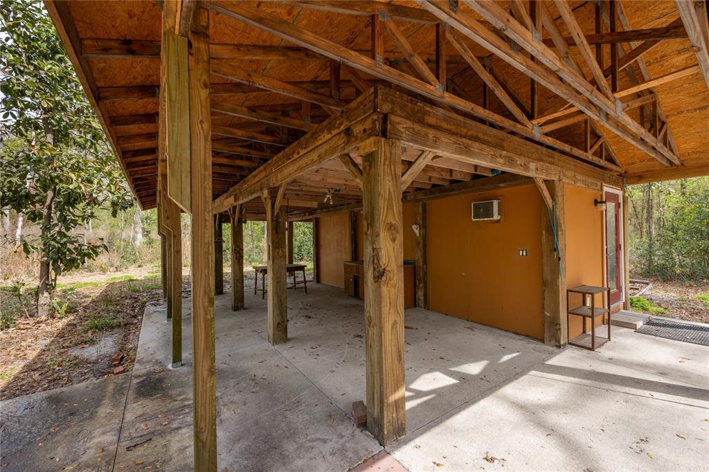 A covered concrete patio features wooden support posts and an exposed truss ceiling — 1187 SW BOSTON TERRACE, FORT WHITE, FL