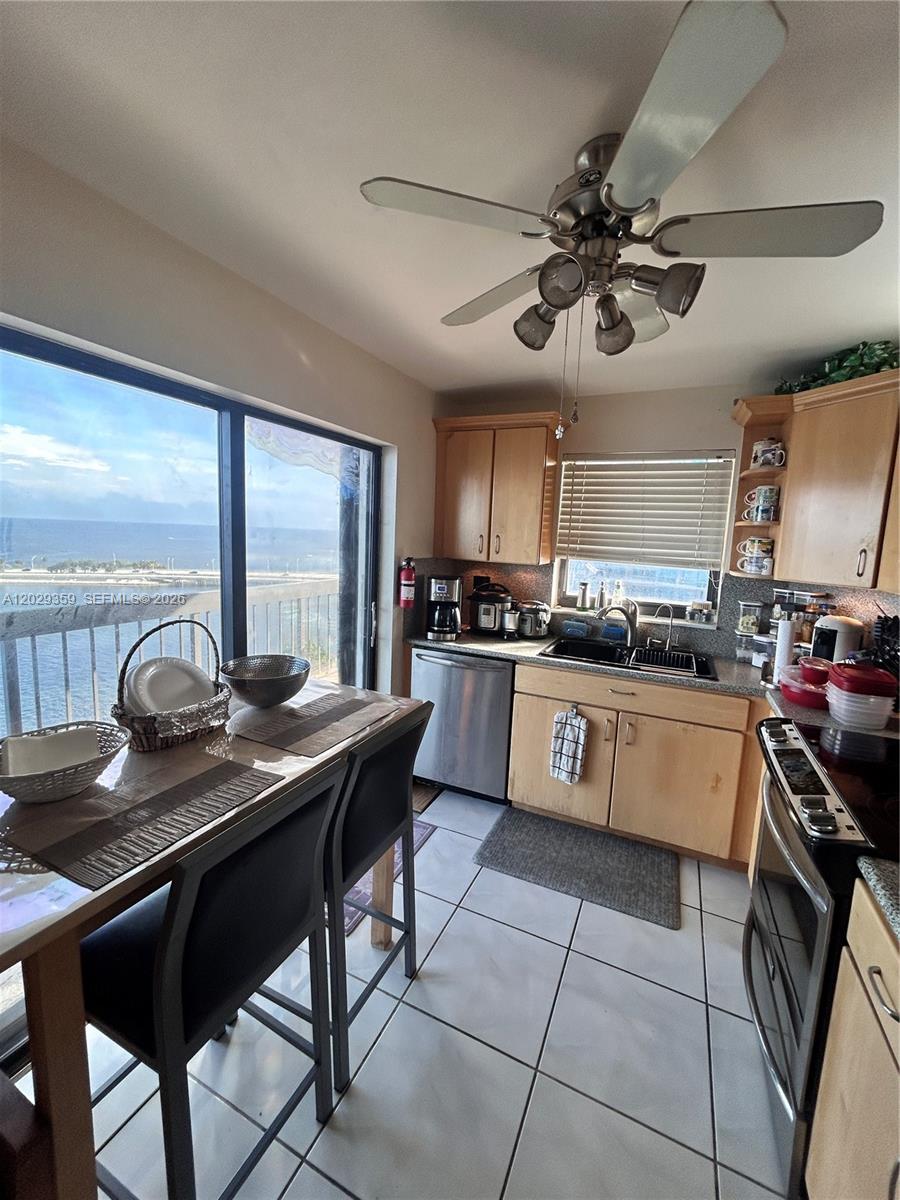 A kitchen with light wood cabinets, tile floors, and a dining area overlooking the ocean — 2333 Brickell Ave # 1402, Miami FL 33129, MIAMI, FL