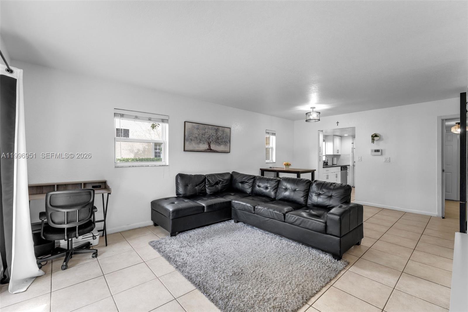 A living room features a black sectional sofa, a gray area rug, and a desk — 8500 SW 109th Ave # 114, Miami FL 33173, MIAMI, FL