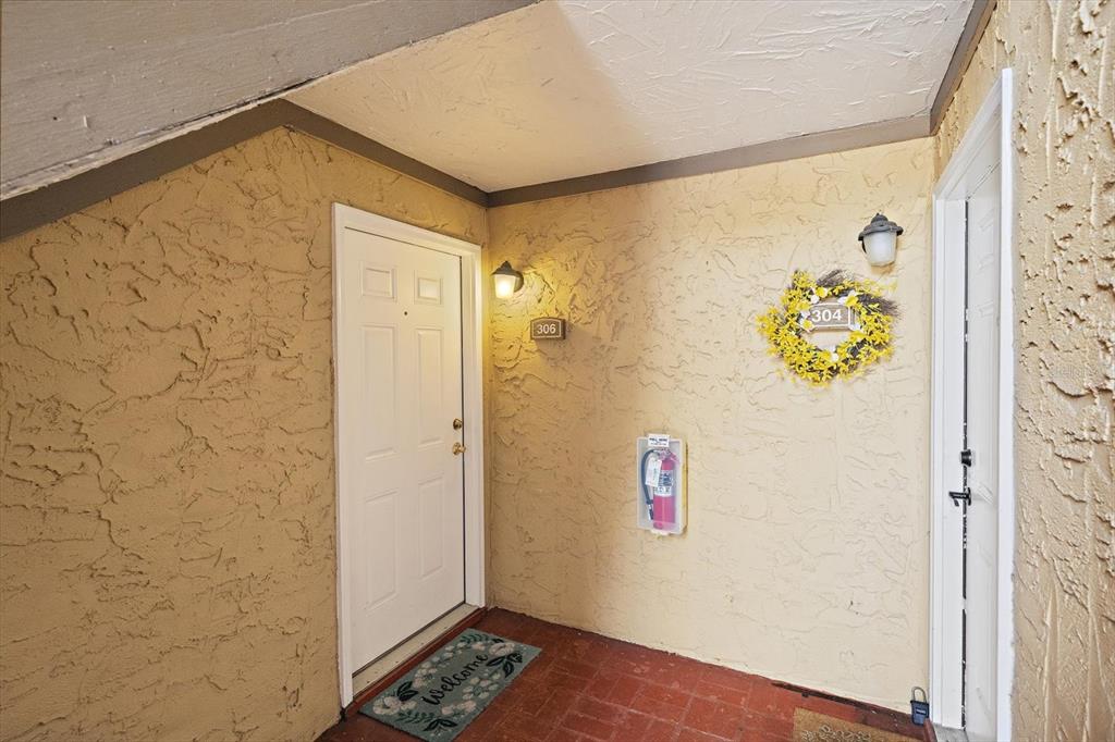 An exterior view of two apartment unit doors with a fire extinguisher between them — 1927 TOUCAN WAY UNIT 306, SARASOTA, FL