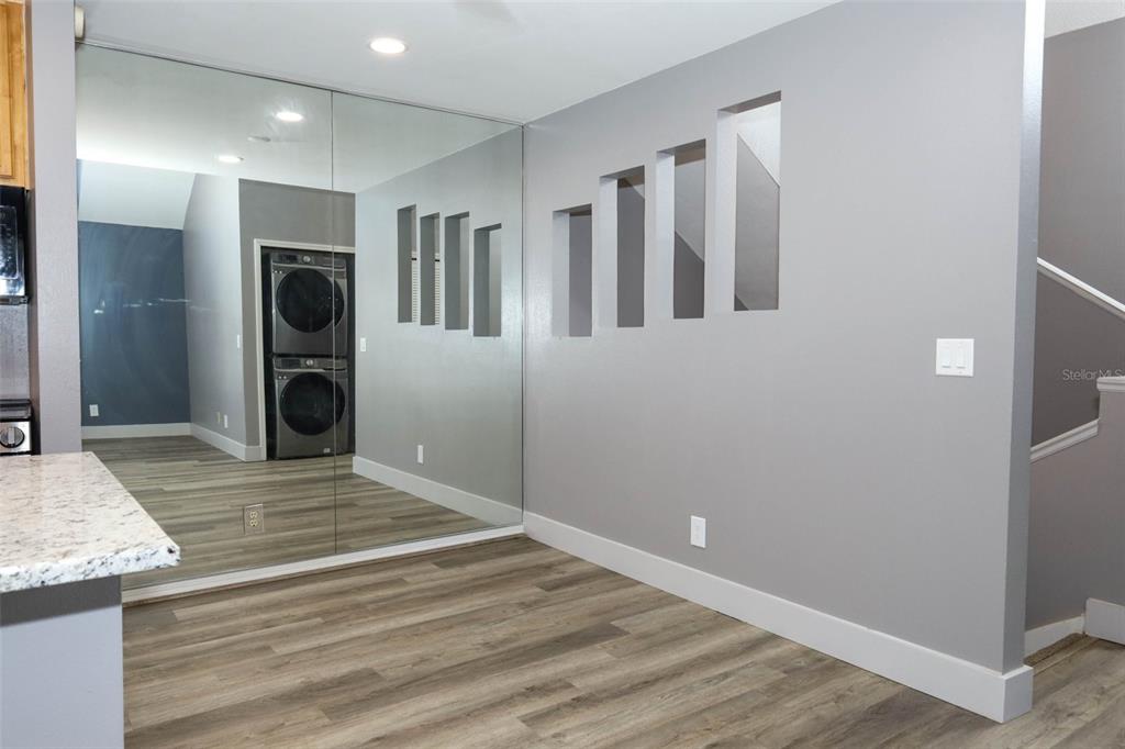 A room with wood-look flooring, a mirrored wall, and rectangular cutouts in a gray wall — 6070 WESTGATE DRIVE UNIT 204, ORLANDO, FL
