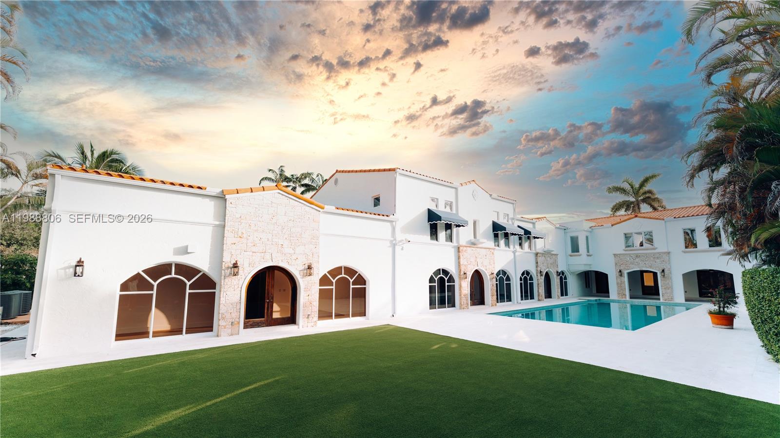 A white Mediterranean-style house features a large swimming pool and a green lawn — 2525 Indian Mound Trl, Coral Gables FL 33134, CORAL GABLES, FL
