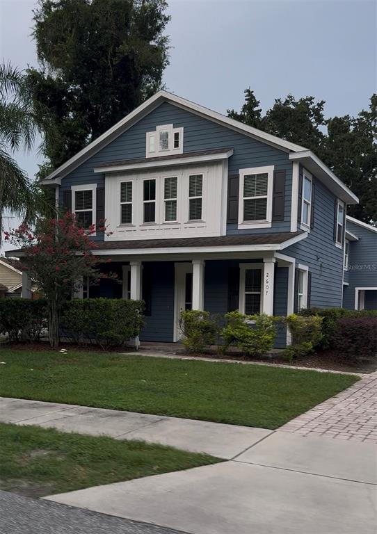 A two-story blue house features a front porch, white trim, and a small lawn — 2607 S BROWN AVENUE, ORLANDO, FL