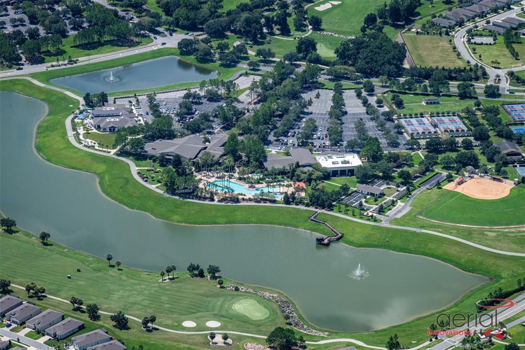 An aerial view shows a community clubhouse with a pool, parking lots, and surrounding lakes — 5475 SW 87TH TERRACE, OCALA, FL