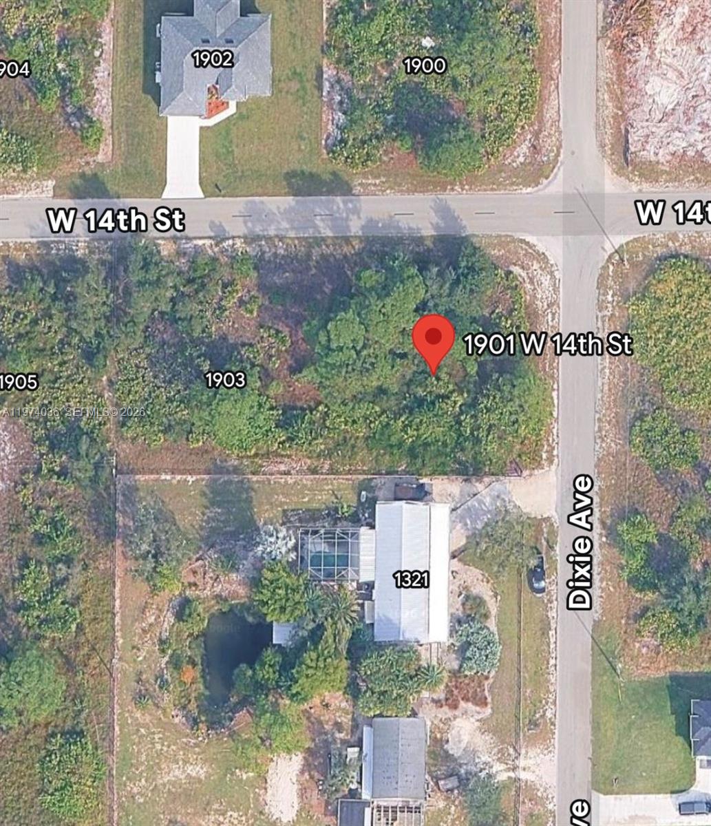 This is an aerial map view showing a vacant, wooded lot at a street corner — 1901 W 14th St, Lehigh Acres FL 33972, LEHIGH ACRES, FL