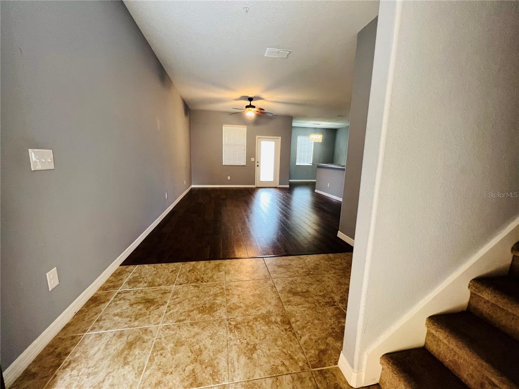 A view from a tiled entryway looking into a living area with dark wood flooring — 1241 PRIORY CIRCLE, WINTER GARDEN, FL