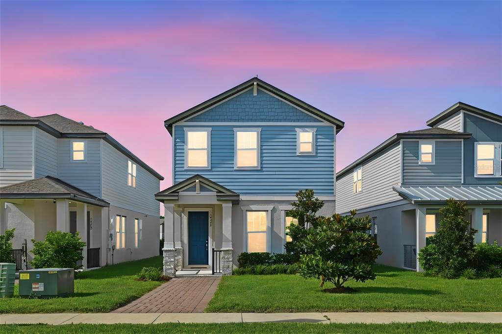 A two-story blue house with a stone-accented porch stands between two neighboring homes — 14268 BRAEMAR STREET, WINTER GARDEN, FL