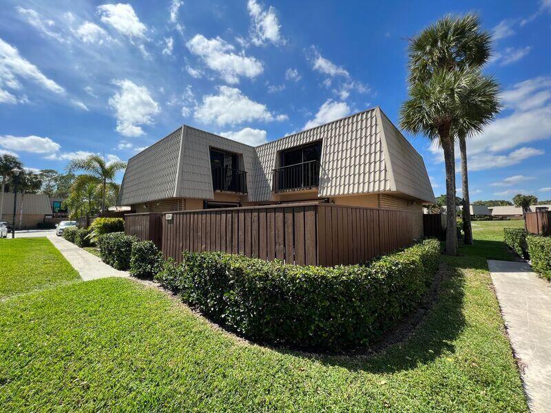 A two-story townhouse with a mansard roof and a wooden privacy fence — 5714 57th Way, West Palm Beach FL 33409, WEST PALM BEACH, FL