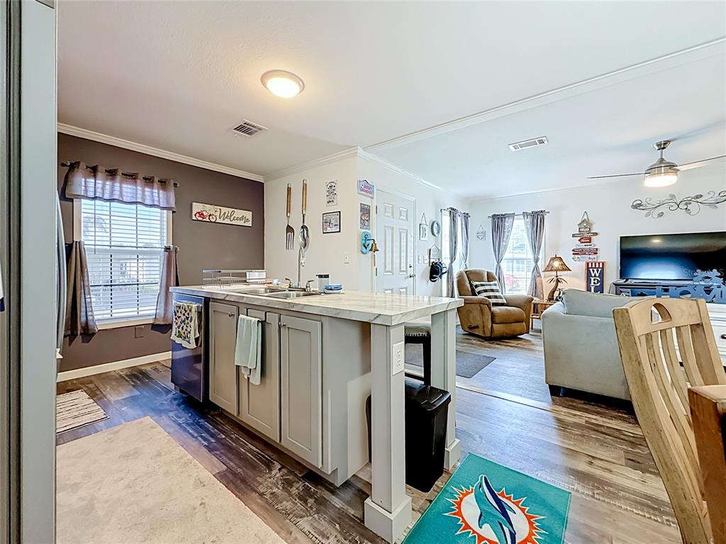 A kitchen island with a marble countertop sits in an open-concept living area — 10485 HOLIDAY SHORES DRIVE UNIT 302, LARGO, FL