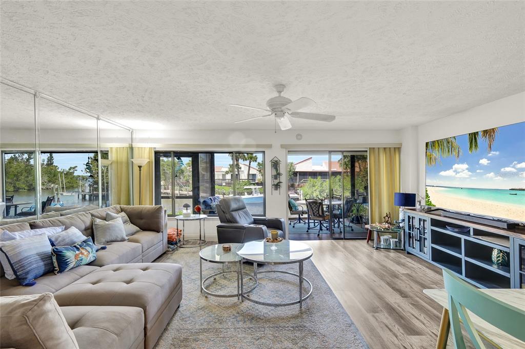A living room features a sectional sofa, glass coffee tables, and sliding doors to a patio — 25188 MARION AVENUE UNIT 1038, PUNTA GORDA, FL