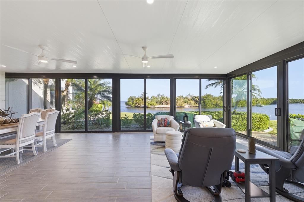 A sunroom with tile floors and large sliding glass doors overlooking a waterfront view — 3270 SOUTHSHORE DRIVE UNIT 72A, PUNTA GORDA, FL