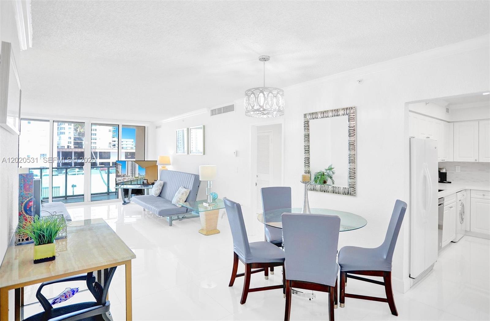 A bright, open-concept living and dining area features white tile floors and a balcony view — 2501 S Ocean Dr, Hollywood FL 33019, HOLLYWOOD, FL