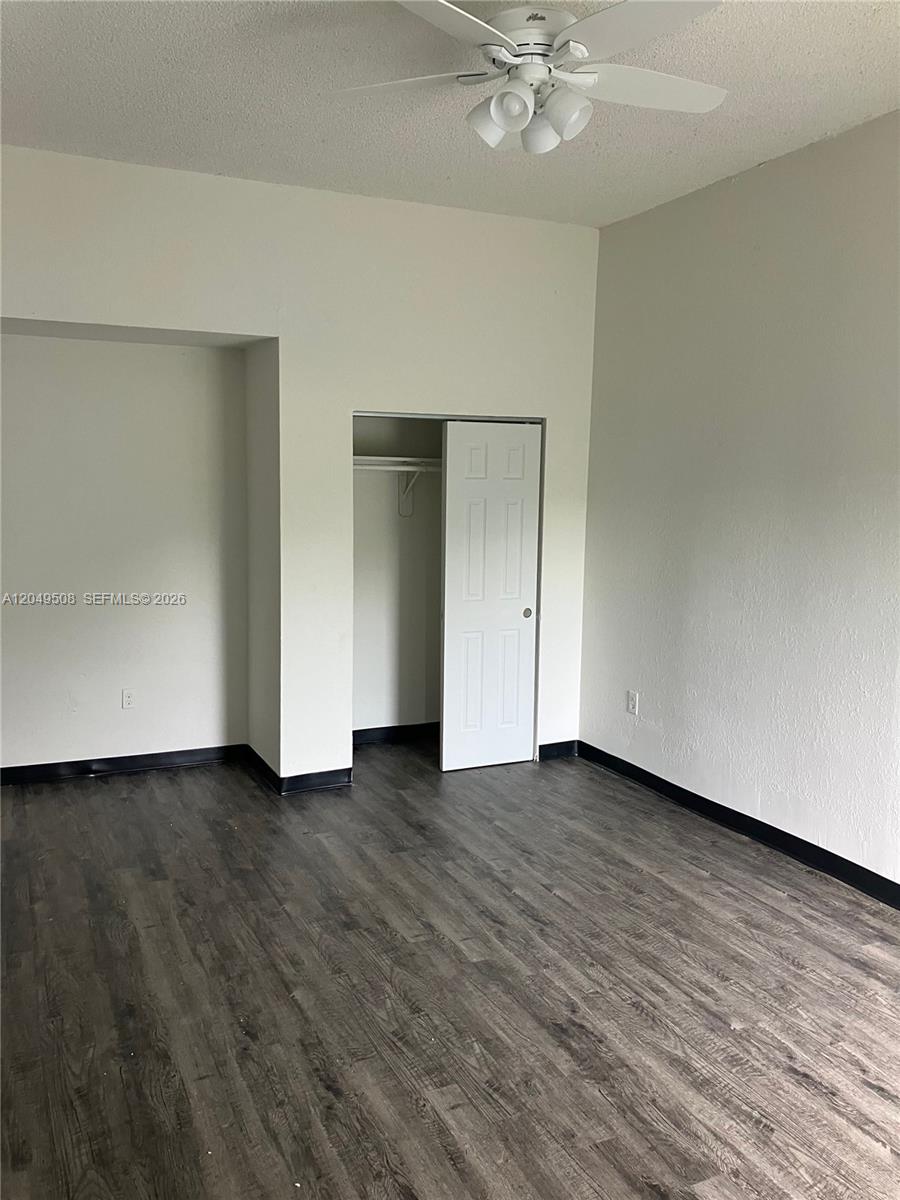 An empty room features wood-look flooring, white walls, a ceiling fan, and a small closet — 467 NW 8th St # 4, Miami FL 33136, MIAMI, FL