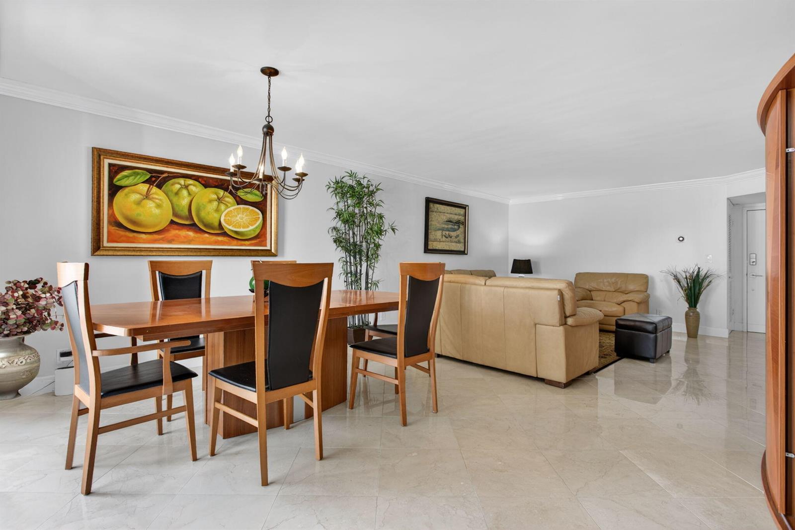 A dining area with a wooden table and chairs sits adjacent to a living room — 1000 S Ocean Boulevard # 5j, Pompano Beach FL 33062, POMPANO BEACH, FL